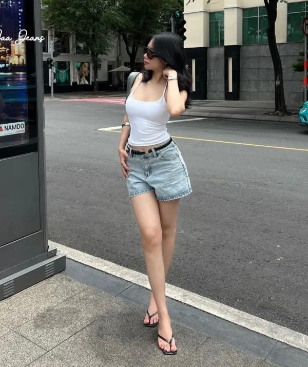 Quần Short Denim Nữ Lưng Vừa Classic Cut Màu Morning Blue, phối áo hai dây trắng, đang bước đi
